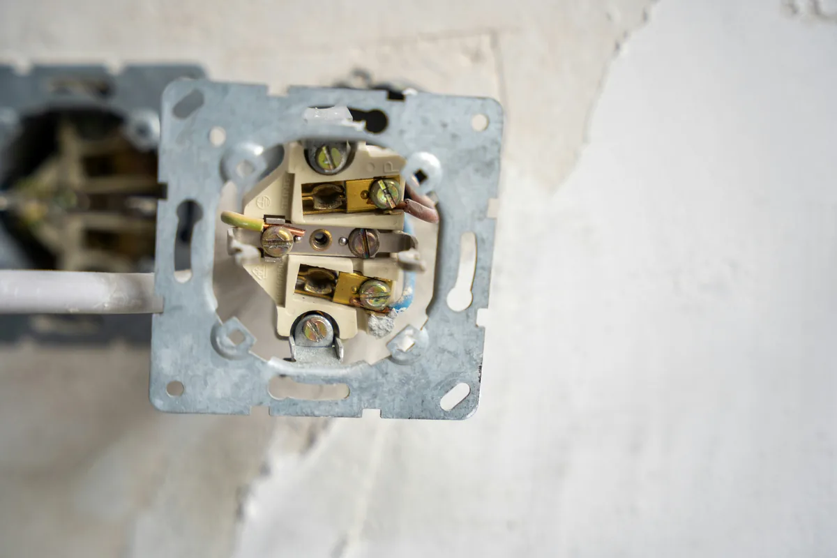 Wandcontactdoos met zichtbare bedrading tijdens installatie